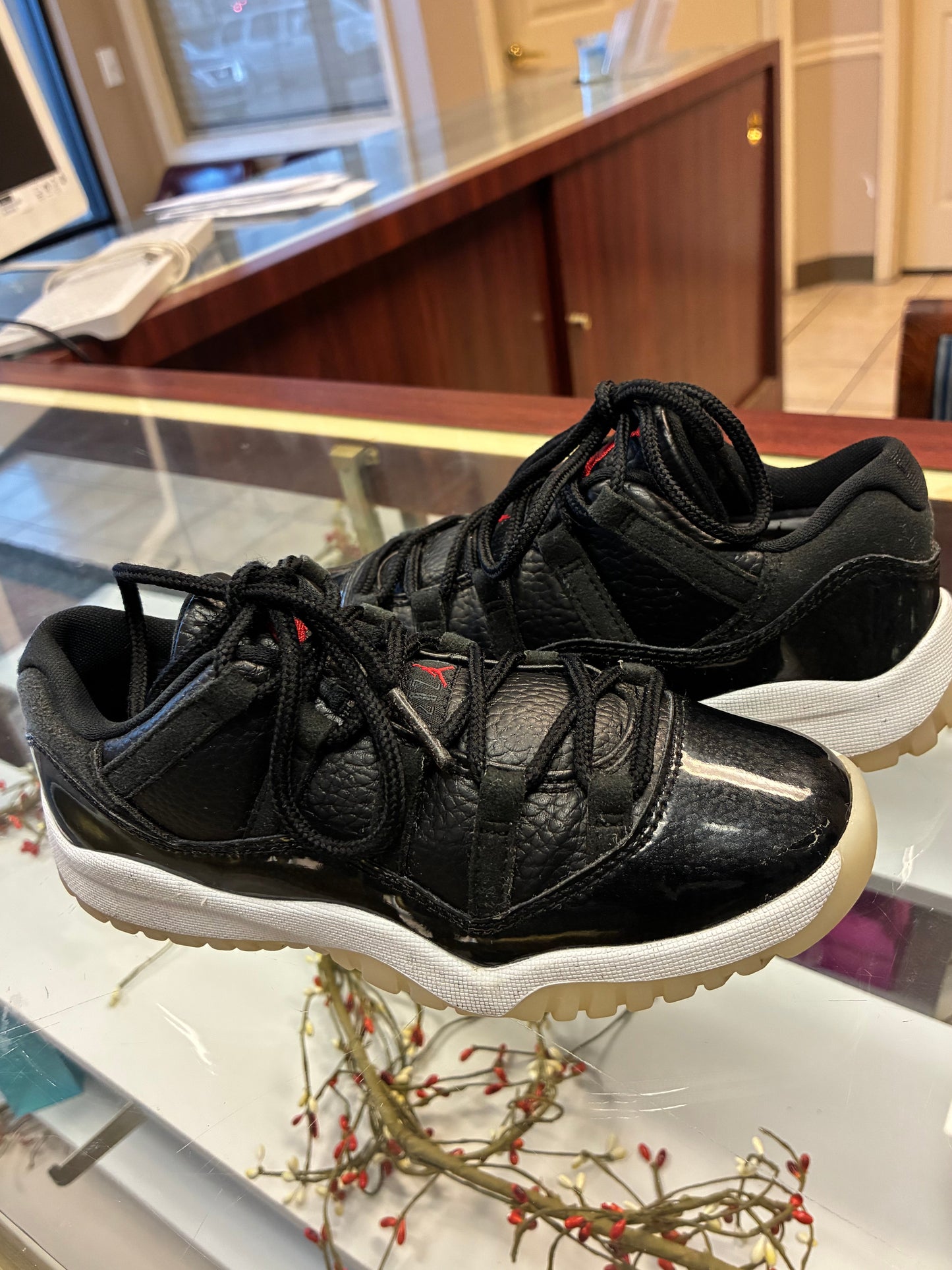 Nike Air Jordan 11 Retro Low Boys size 1Y sneakers in black leather with a glossy finish