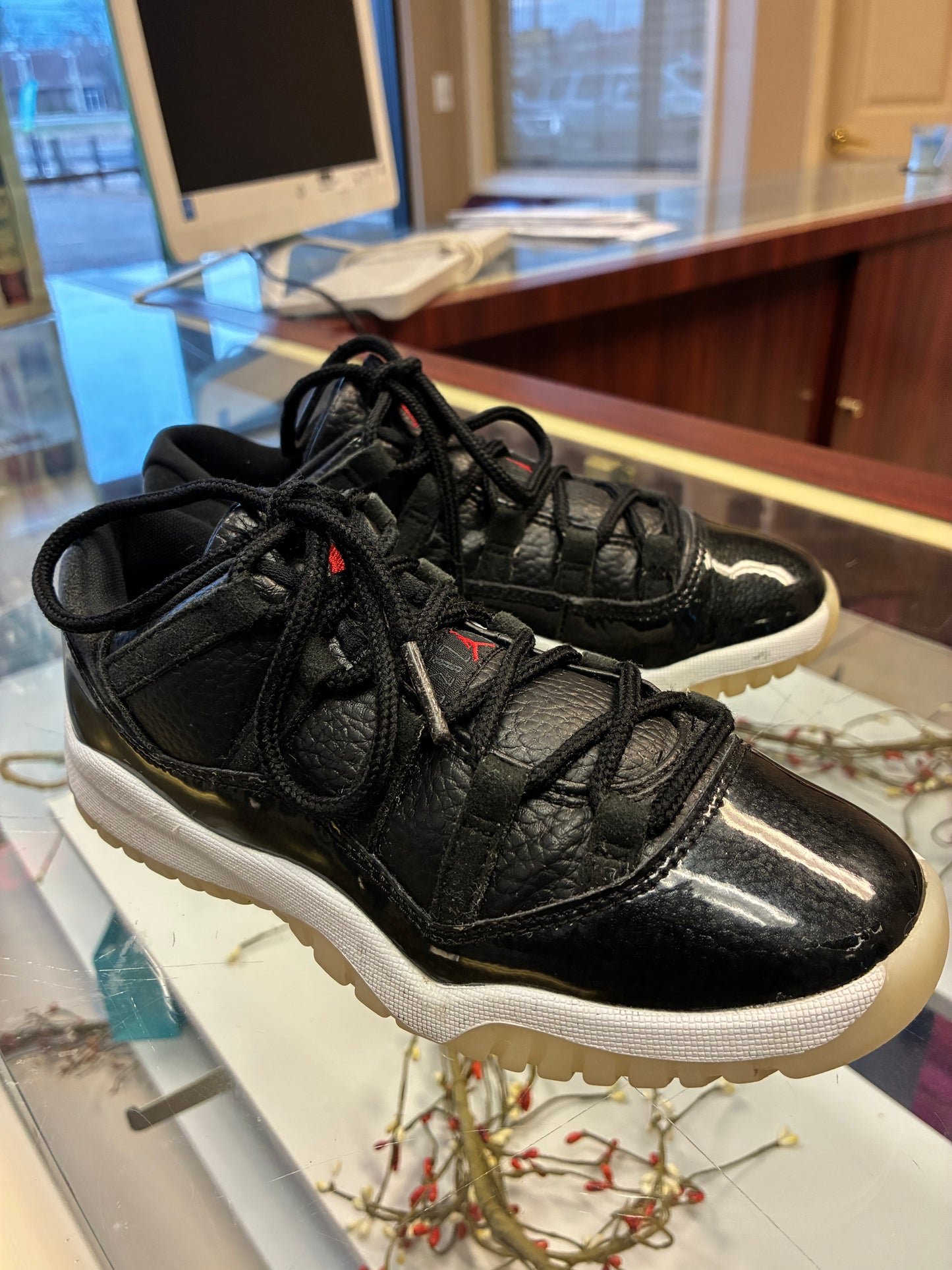 Nike Air Jordan 11 Retro Low Boys size 1Y sneakers in black leather with a glossy finish