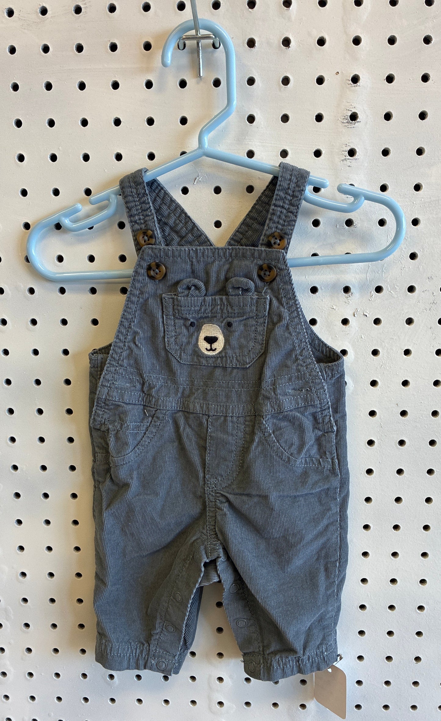 Newborn Carter's baby boy gray corduroy long overalls featuring a bear face design on the bib pocket